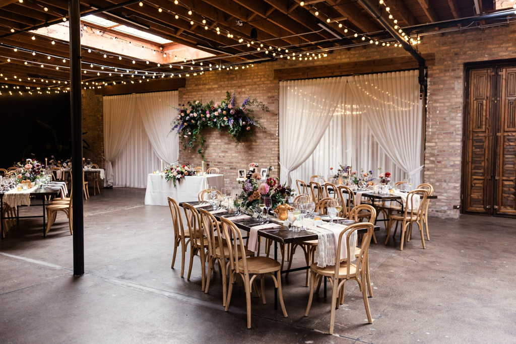 Wedding reception space with decorated tables, floral arrangements, and string lights at The Arbory Chicago