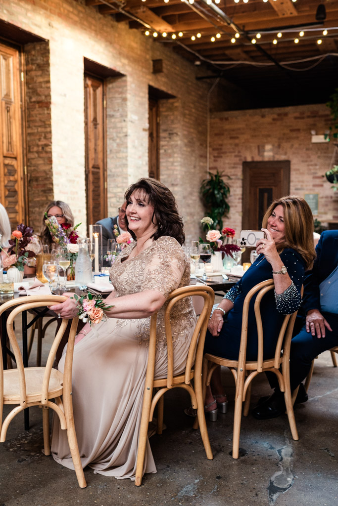 Guests in formal dress smile during a wedding reception speech at The Arbory Chicago