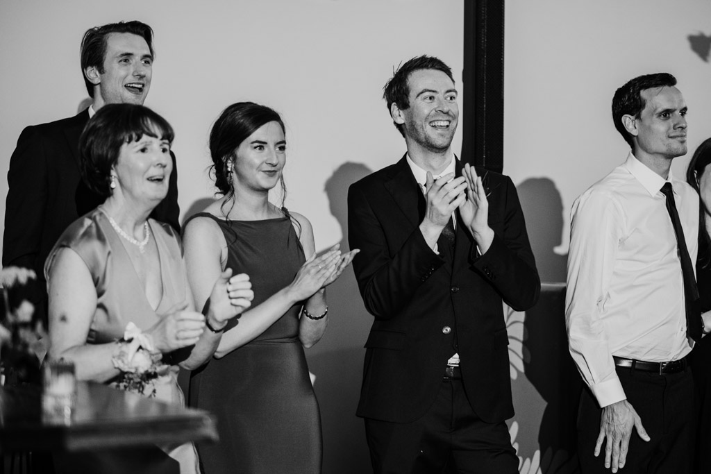 Black and white photo of guests smiling and clapping during The Arbory Chicago, wedding reception