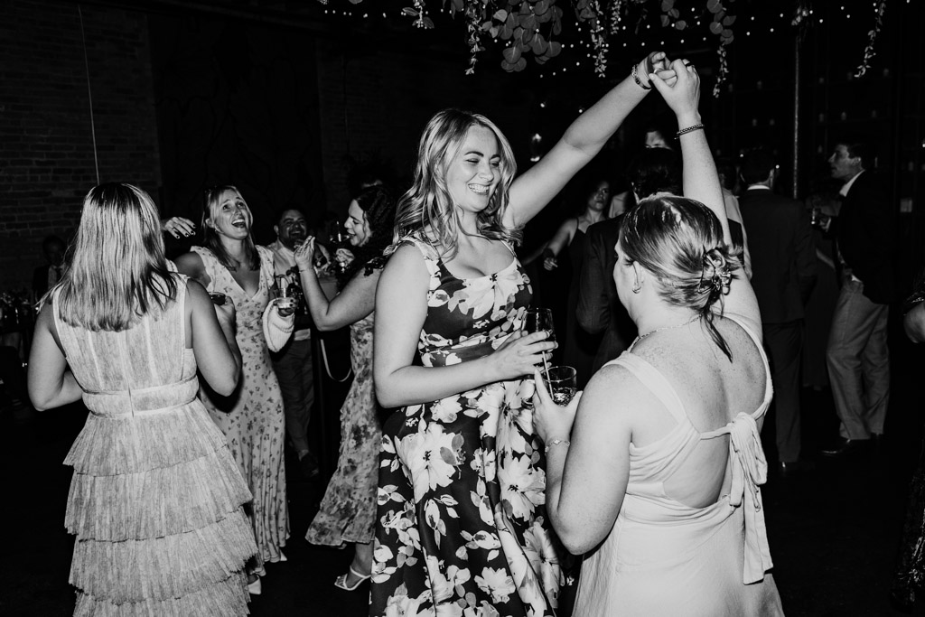 Black and white photo of guests dancing together during wedding reception at The Arbory Chicago