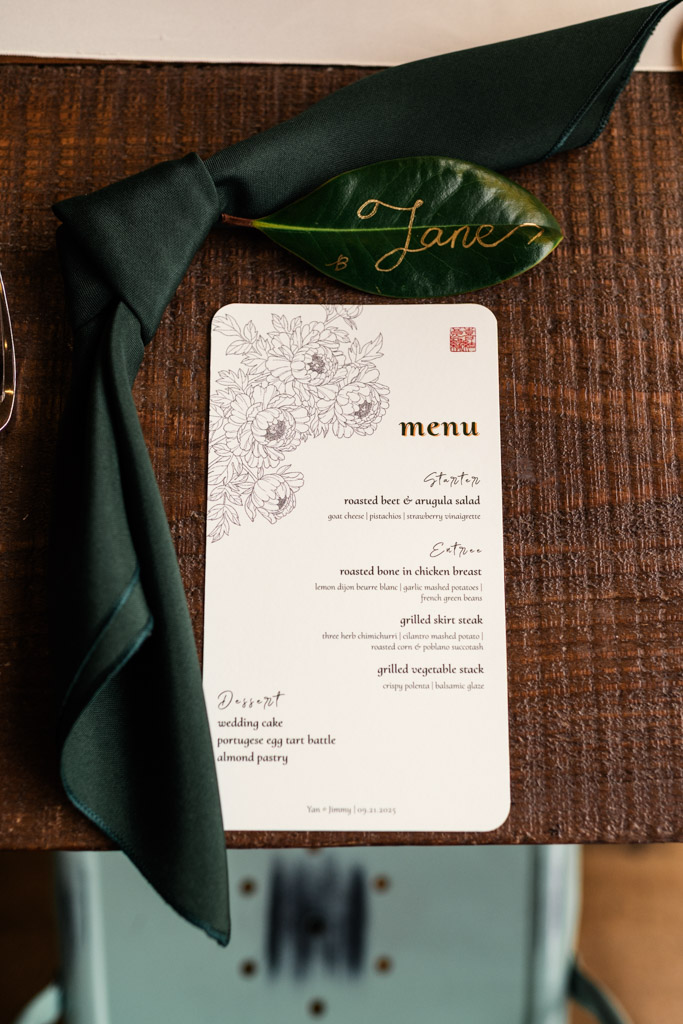 A wedding menu card with a floral design sits beside a green napkin for wedding reception at The Joinery in Chicago