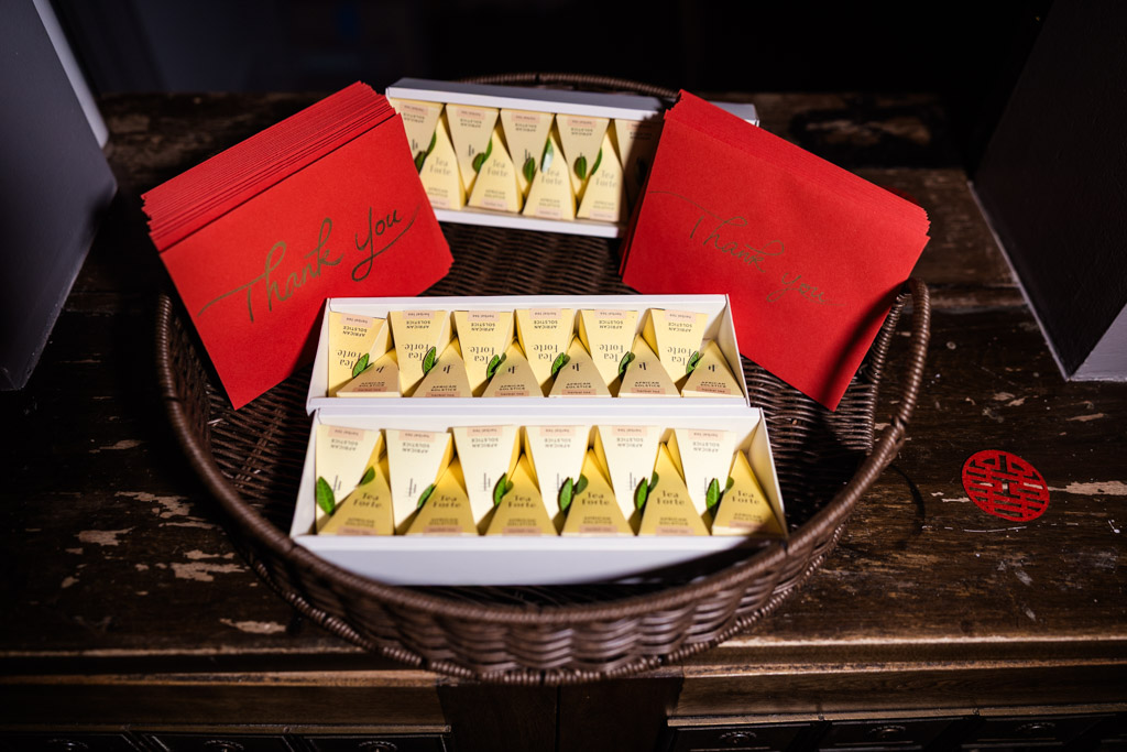 A basket with red thank you cards and triangular yellow boxes sits on a wooden table for wedding celebration at The Joinery in Chicago