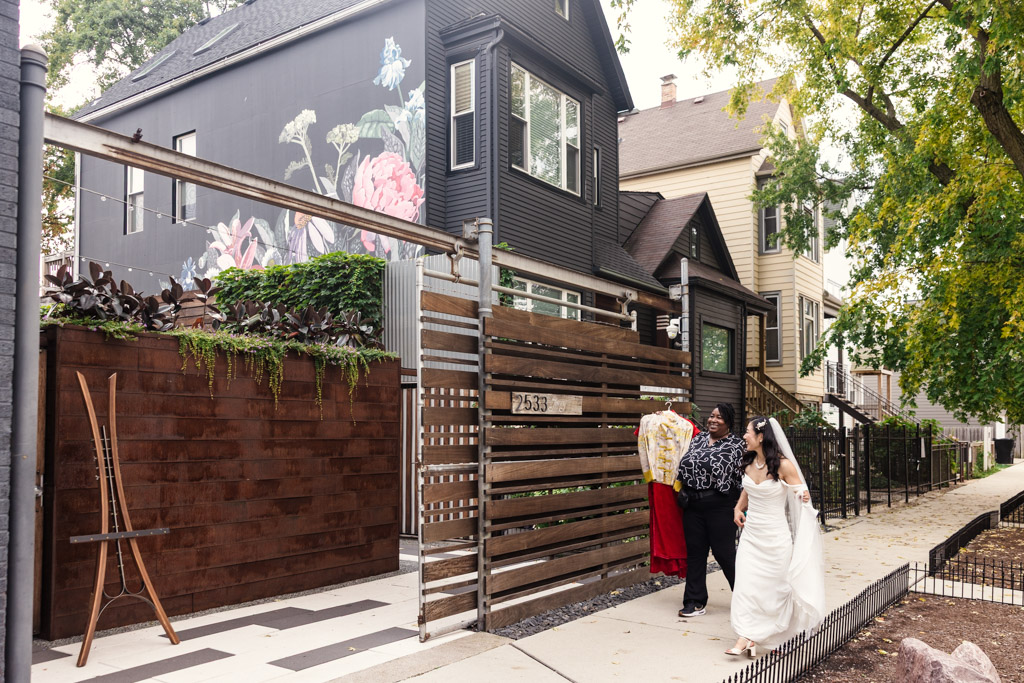 Bride walks with a companion down a city sidewalk before her wedding ceremony at The Joinery in Chicago