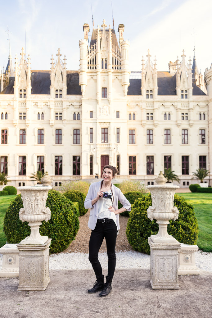 Photographer Emma Mullins smiles in front of Chateau Challain castle in Loire Valley, France