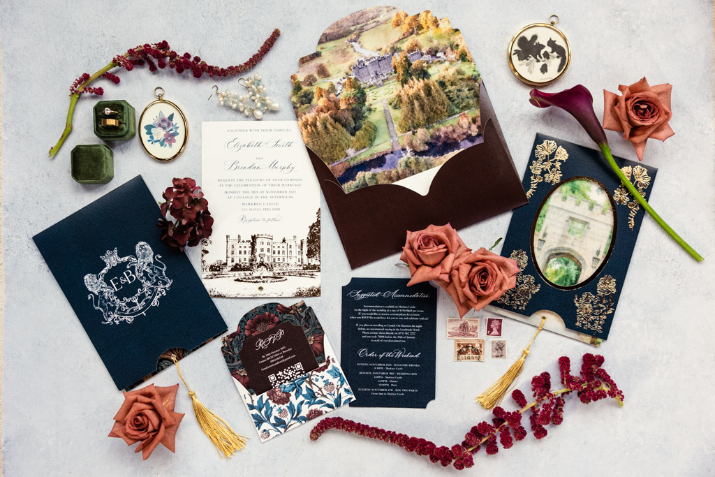 Flat lay of wedding invitations, flowers, jewelry, and vintage postage on a light background for Markree Castle wedding celebration