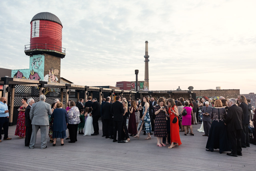 Guests in formal attire on the rooftop of Lacuna Lofts during cocktail hour