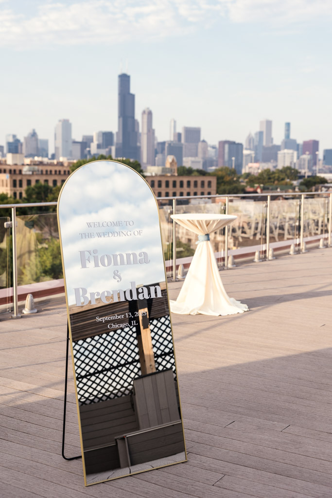 Mirrored wedding welcome sign for Lacuna Lofts wedding celebration with the Chicago skyline in the background
