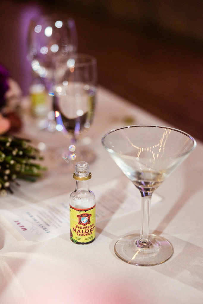 A martini glass and a small bottle of Malört sit on a table at Lacuna Lofts
