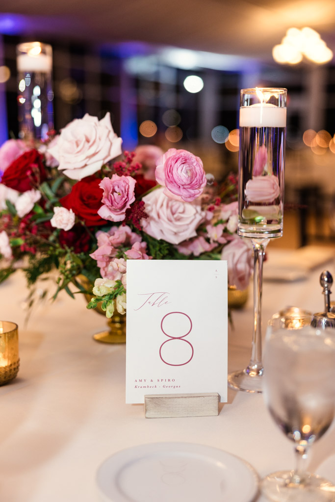 Table with a floral centerpiece, candles, and a card reading 