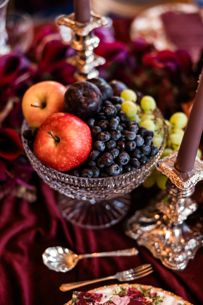 A crystal bowl filled with apples, grapes, and blueberries on guest table for Markree Castle wedding reception