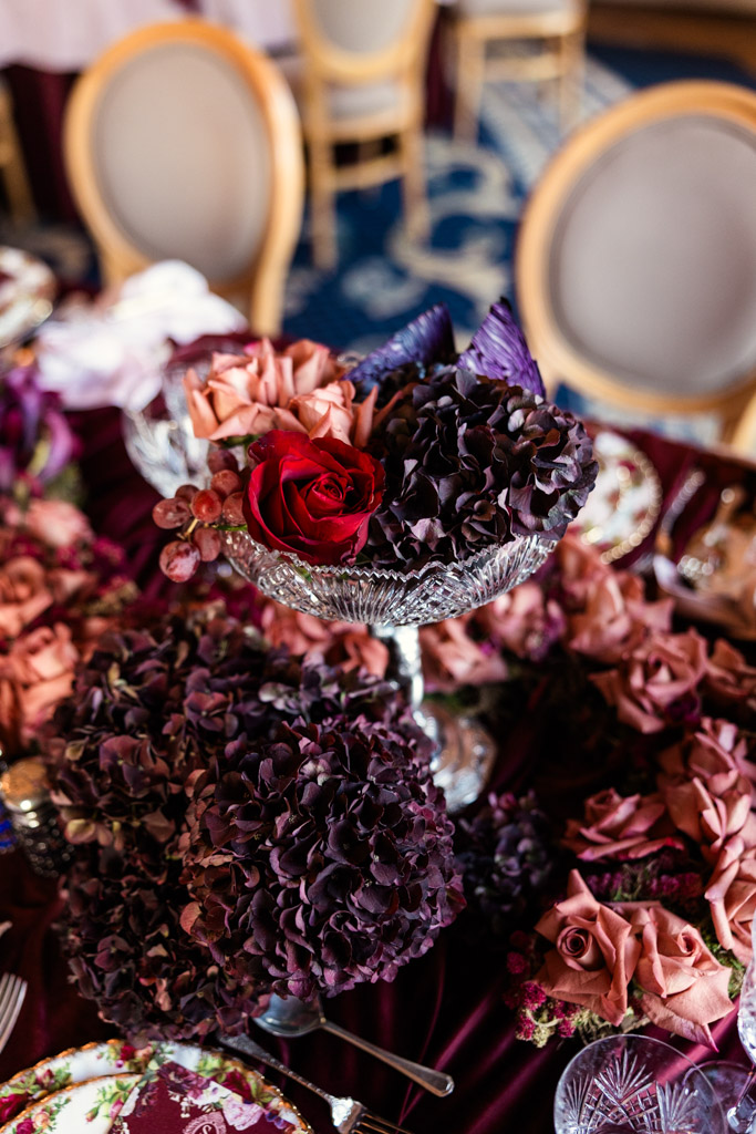 Crystal centerpiece filled with purple hydrangeas, roses, and decorative leaves on a guest table for Markree Castle wedding reception