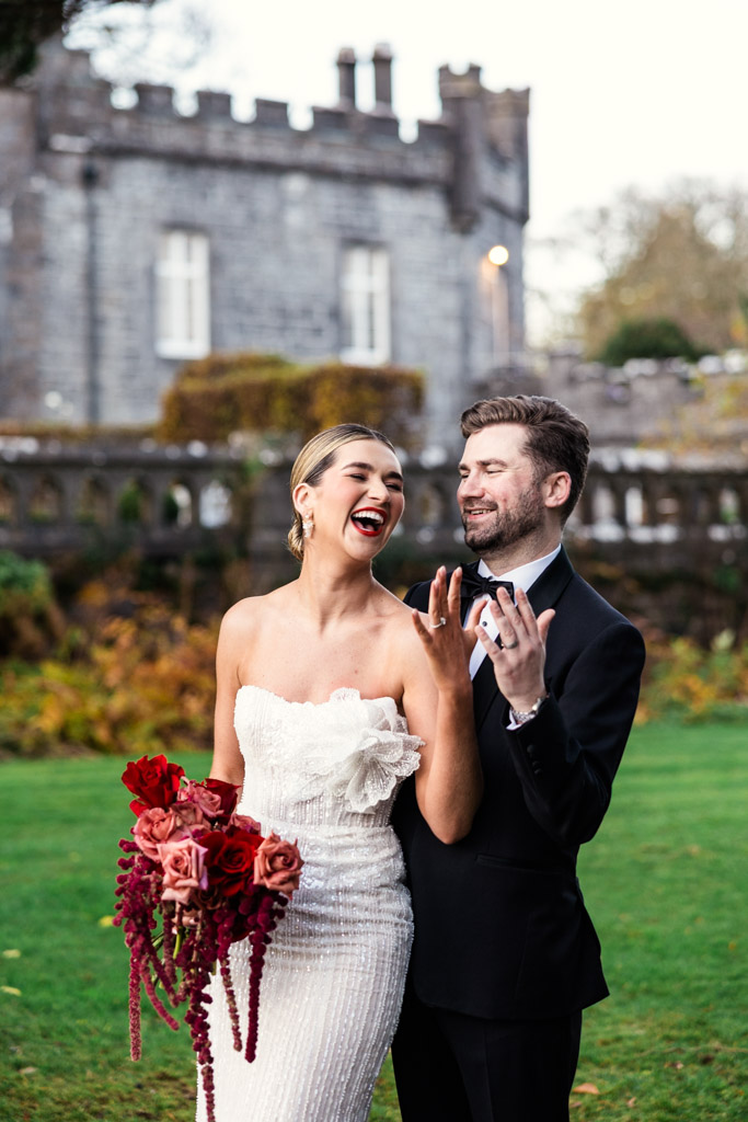 Bride and groom smiling and laughing outside Markree Castle, showing off their rings