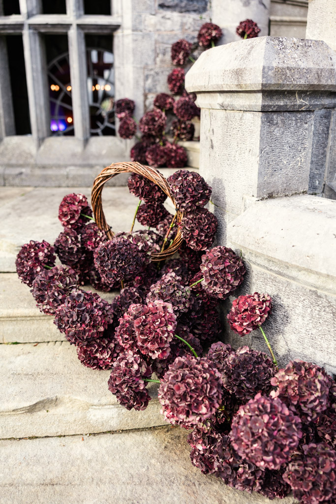 A basket of purple hydrangeas and loose blooms adorns the stone steps outside Markree Castle