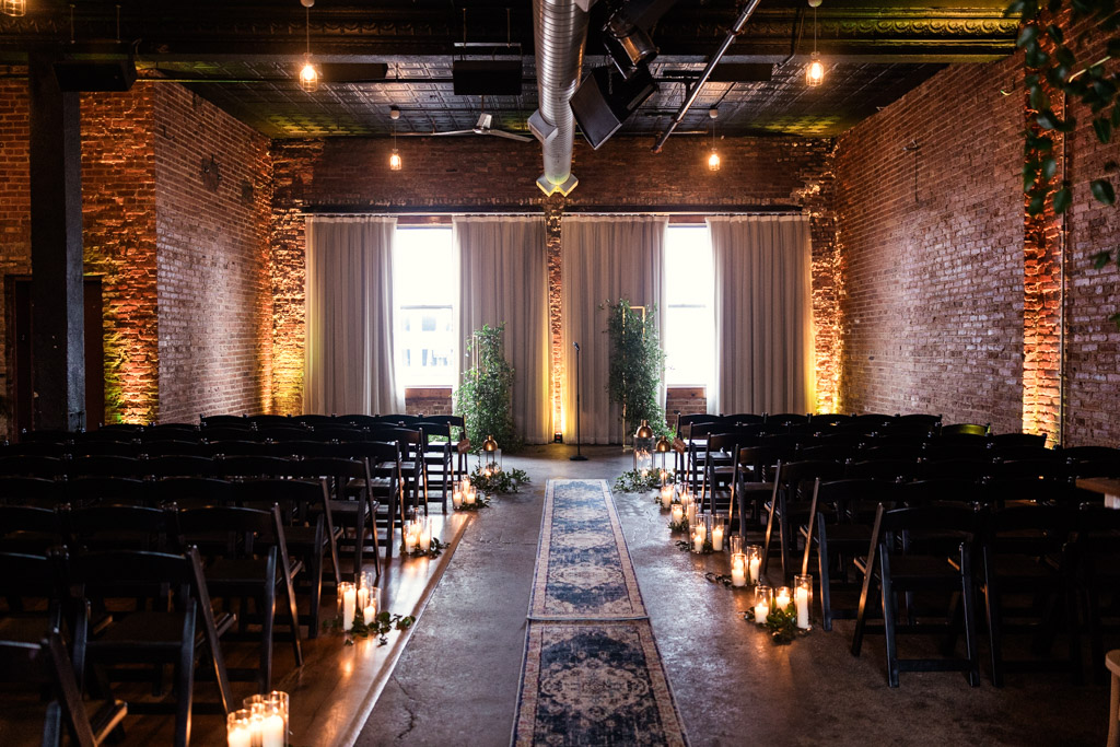 Aisle with candles and chairs set up for a wedding in the wedding ceremony space at Bottom Lounge