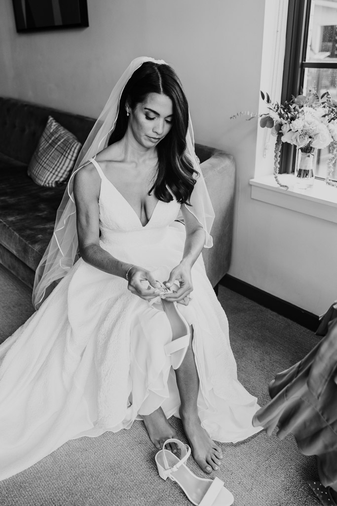 Black and white photo of bride in a white dress on a couch before her Bottom Lounge wedding