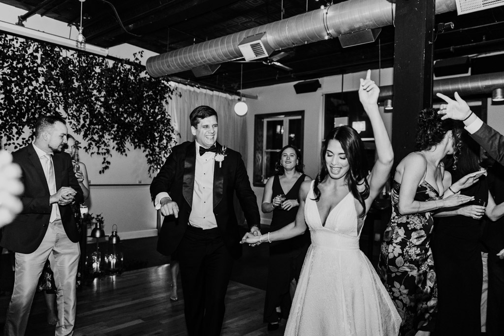 Bride and groom dance together at their Bottom Lounge wedding reception, surrounded by cheering guests