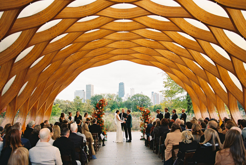 Film photo of couple holding hands during their Lincoln Park Honeycomb wedding ceremony surrounded by guests