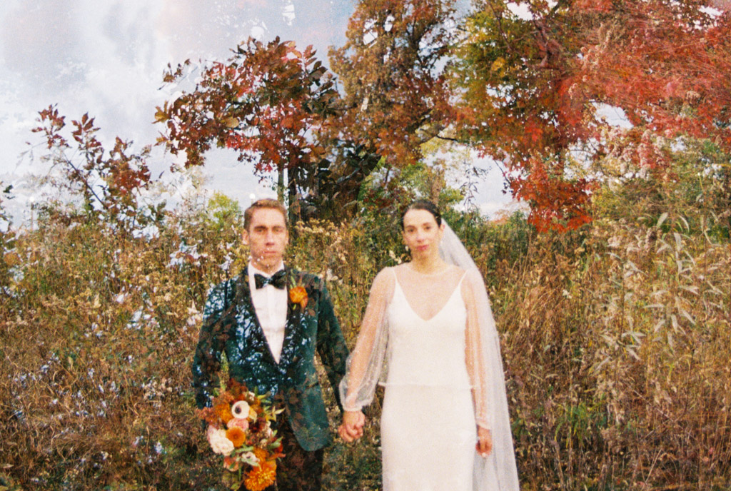 Creative double exposure film photo ofride and groom holding hands in Lincoln Park surrounded by autumn trees and wildflowers