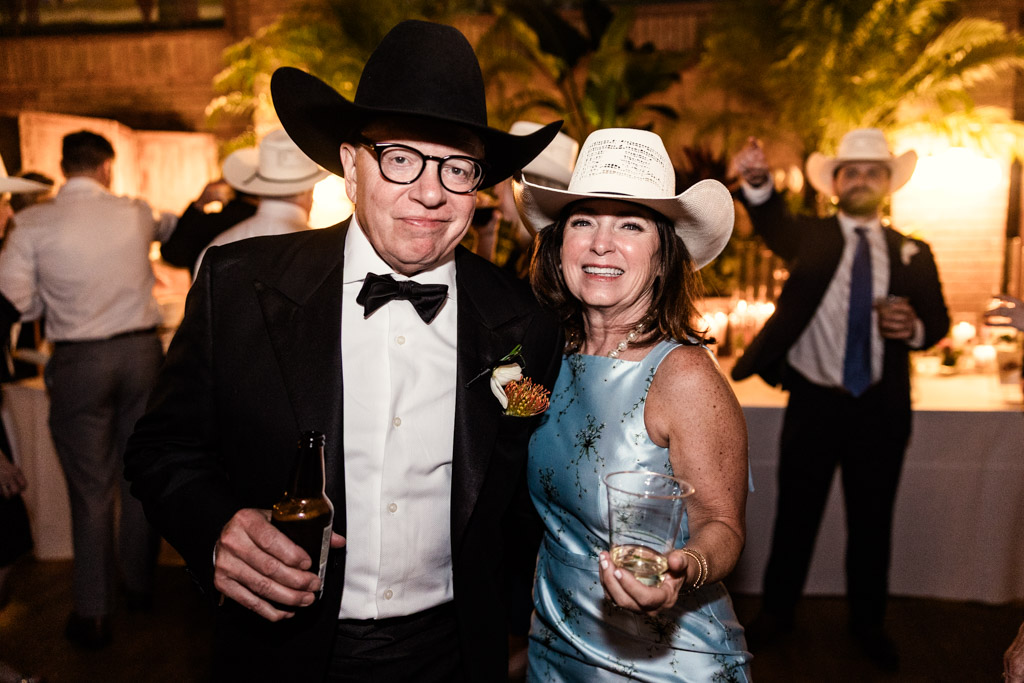 Smiling man and woman in cowboy hats pose at Cafe Brauer wedding reception