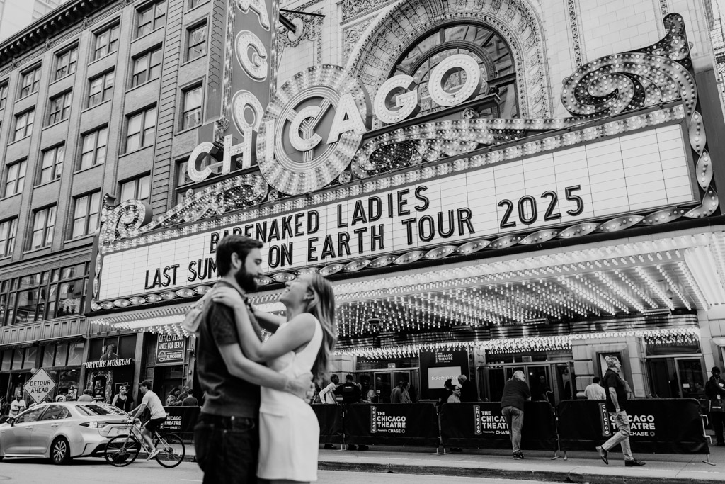 Black and white photo of couple outside the Chicago Theatre during their summer engagement session