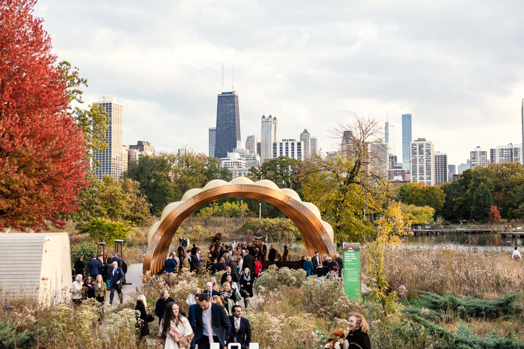 Guests leaving the Lincoln park Honeycomb after a wedding ceremony with skyscrapers and autumn trees in the background