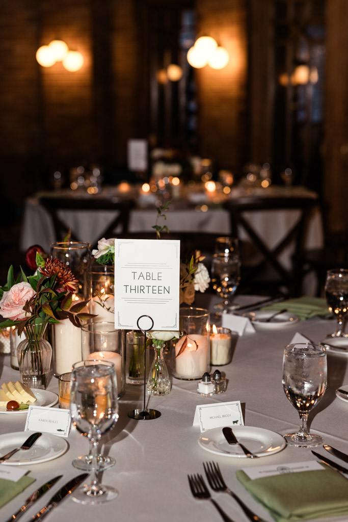 Table set for dinner with candles, flowers, glassware for Cafe Brauer wedding reception