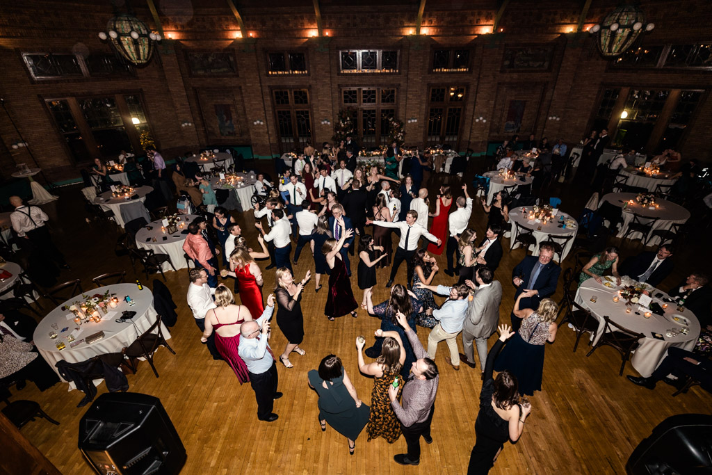 A large group of guests together on the dance floor inside Cafe Brauer's wedding reception hall