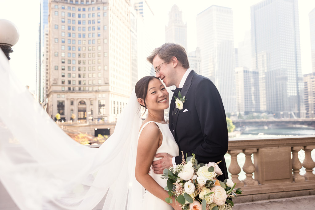 Bride and groom smiling and embracing outdoors with Chicago skyscrapers in the background