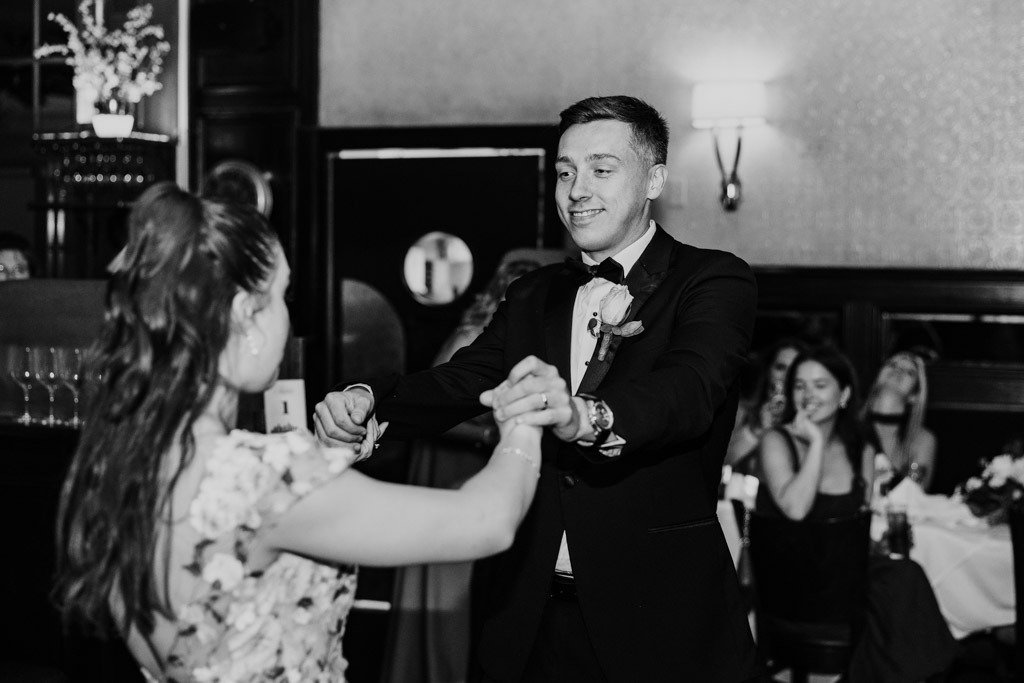 Newlyweds dance together at their Mon Ami Gabi wedding reception while guests watch and smile in the background