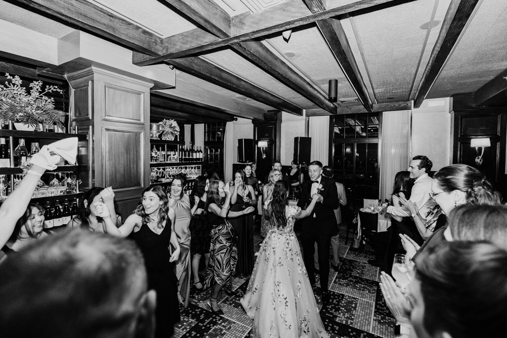 Black and white photo of newlywed couple dancing in the center of a crowded, elegant room at their Mon Ami Gabi wedding reception