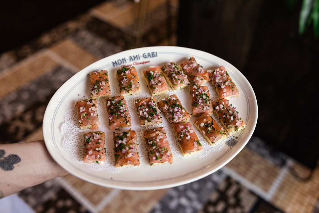 A plate of smoked salmon canapés garnished with herbs and diced onions for Mon Ami Gabi wedding reception