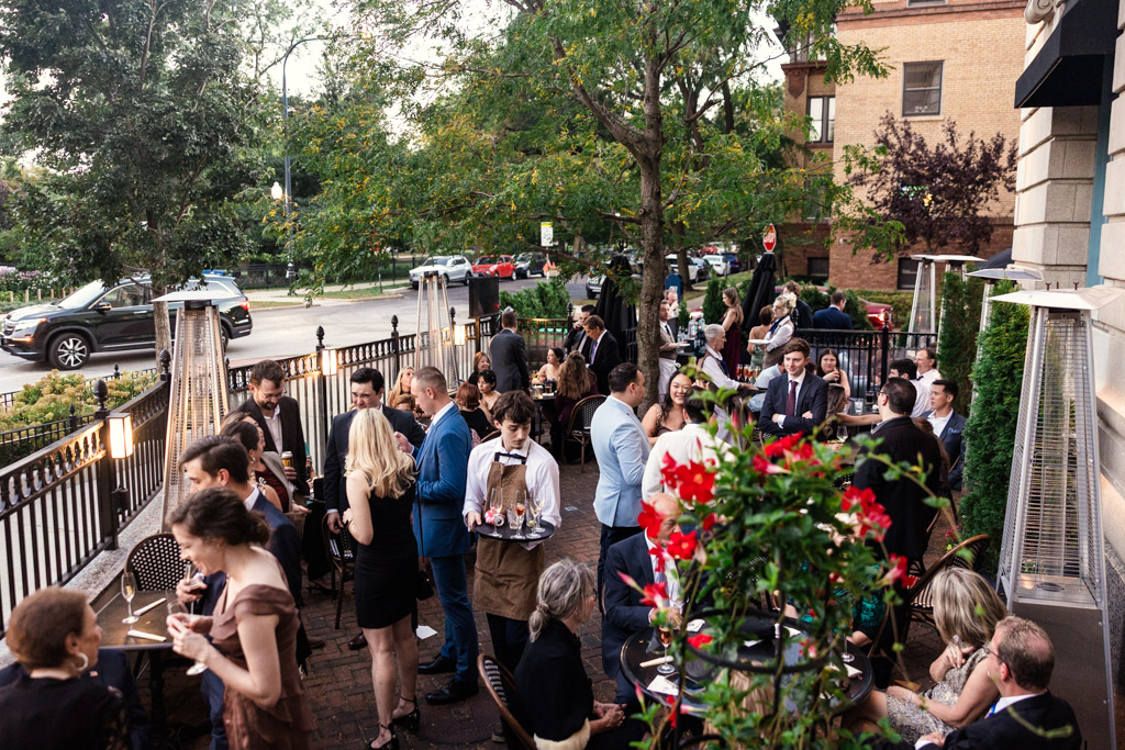 Wedding guests dressed formally mingling and dining outdoors on the patio of Mon Ami Gabi