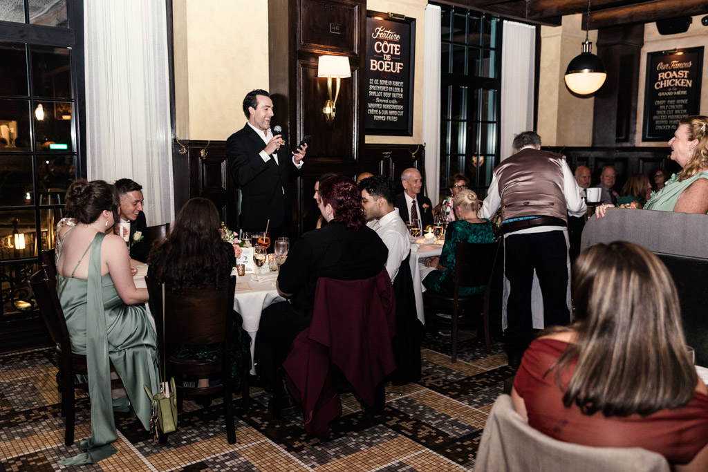 Best Man in a suit gives a speech during Mon Ami Gabi wedding reception