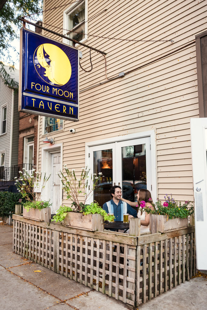 Couple sits outside at Four Moon Tavern during their Roscoe Village engagement session