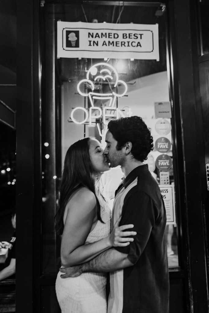 Couple kisses in front of the Scooters Frozen Custard shop window during their Roscoe Village engagement session