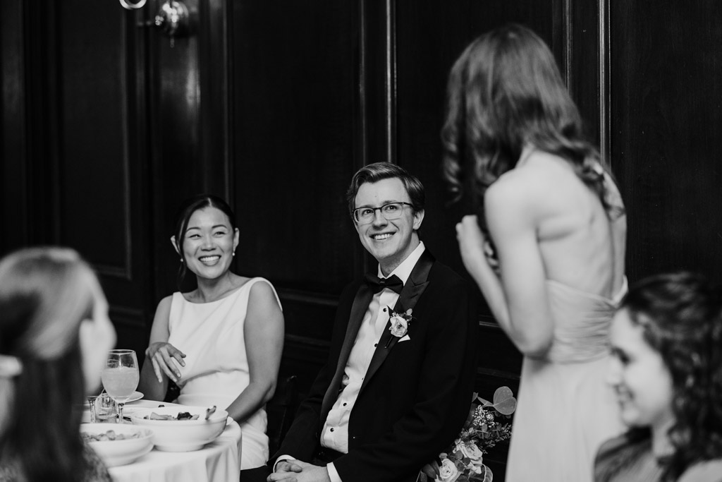 Black and white photo of Maid of Honor speaking to happy newlyweds during Salvatore's wedding reception
