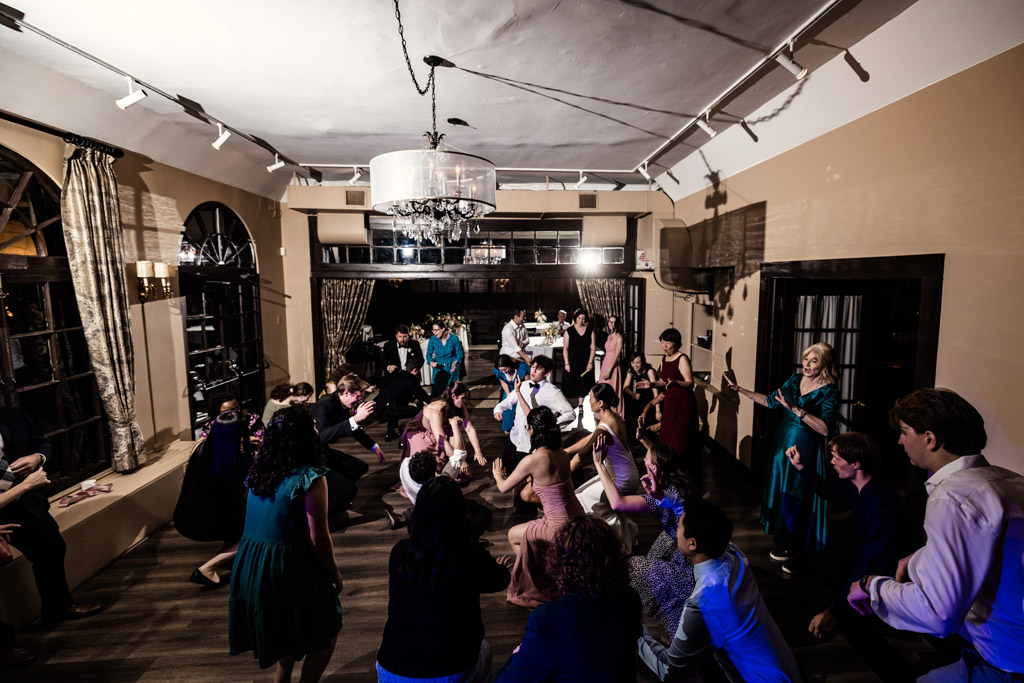 Guests dancing energetically in Salvatore's well-lit room with large windows and brown walls