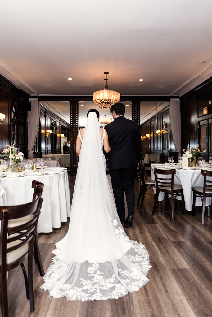 Bride and her brother walk hand in hand into her wedding ceremony at Salvatore's in Chicago's Lincoln Park neighborhood