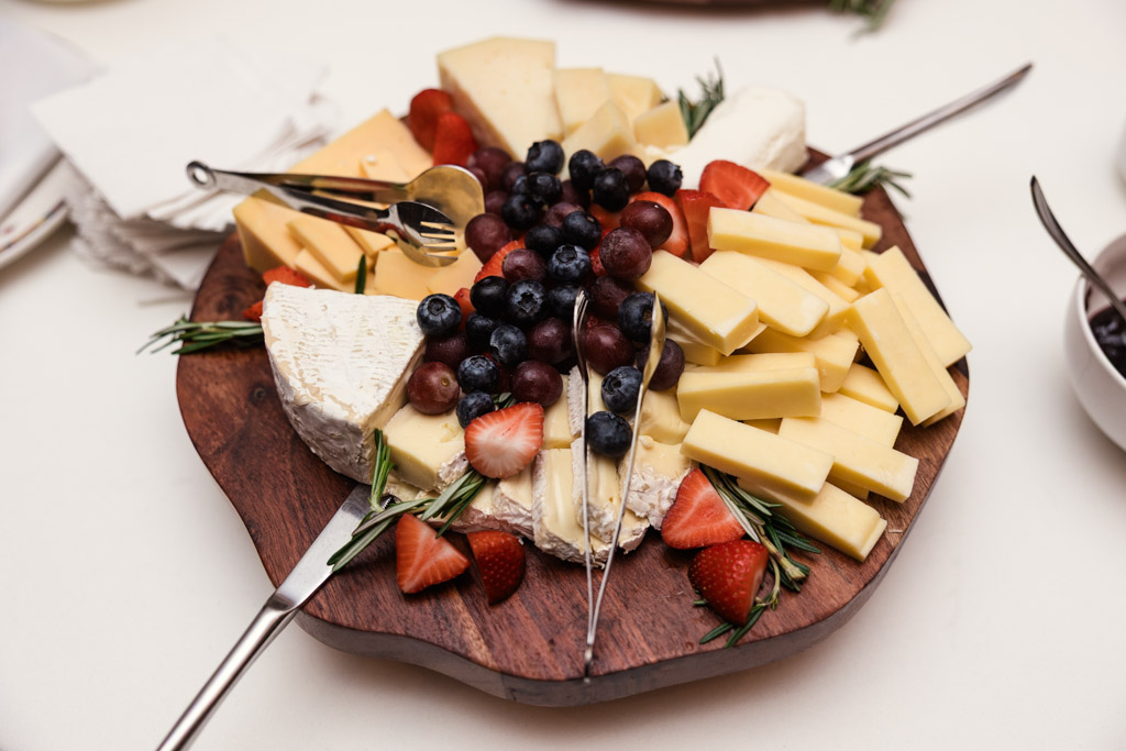Salvatore's wooden platter features assorted cheeses, strawberries, blueberries, grapes