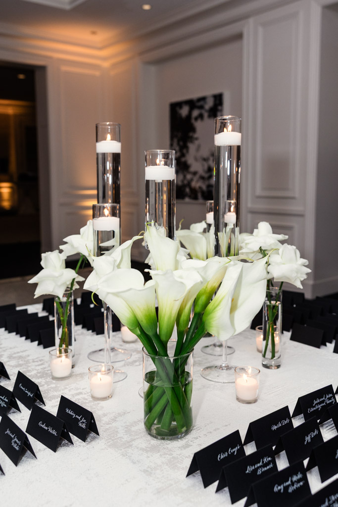 White calla lilies and floating candles arranged on a table with place cards for wedding reception at The Four Seasons Chicago