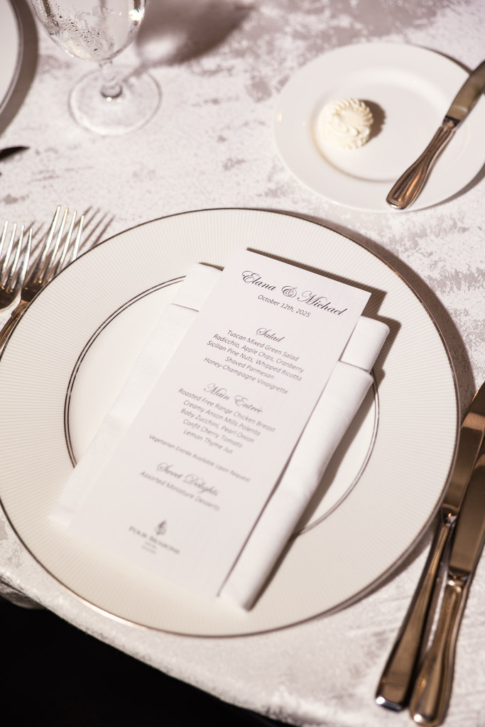 Place setting for wedding reception at The Four Seasons Chicago, featuring a printed menu on a white plate