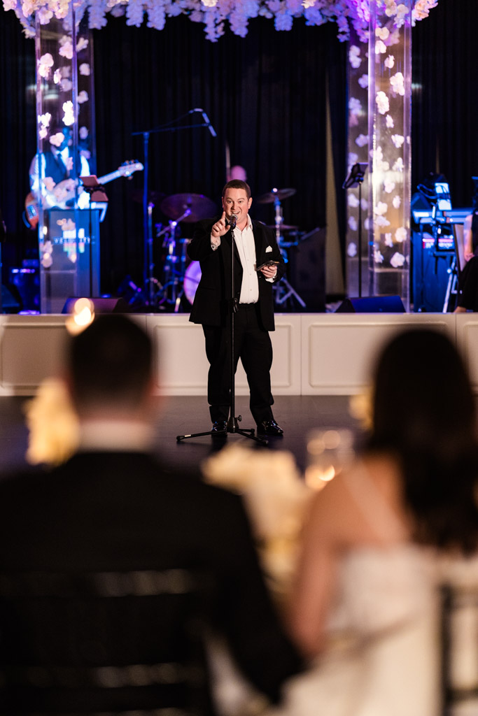 Best Man gives a speech during wedding reception at The Four Seasons Chicago, with the newlyweds in the foreground