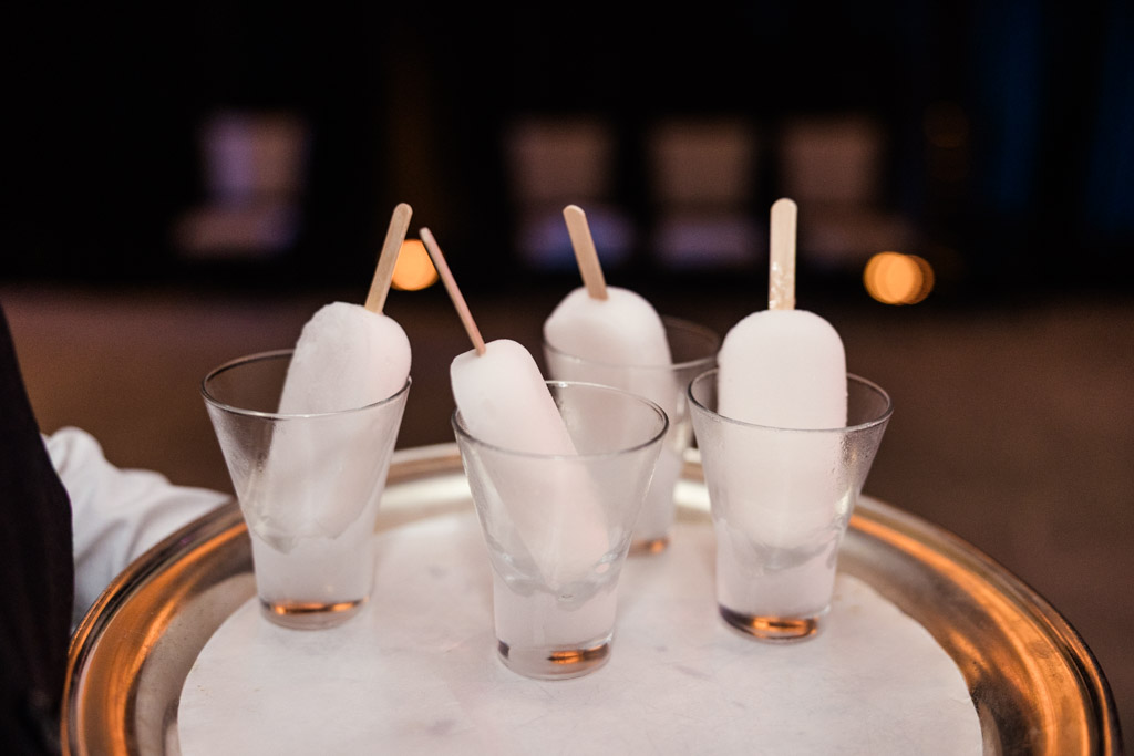 Four white popsicles in glasses on a silver tray, each with a wooden stick, for wedding reception at The Four Seasons Chicago