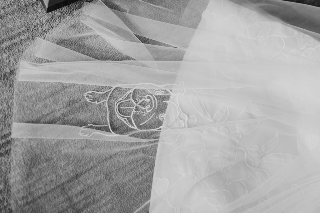 Black and white photo of sheer wedding veil with floral and pug dog embroidery for wedding celebration at The Four Seasons Chicago