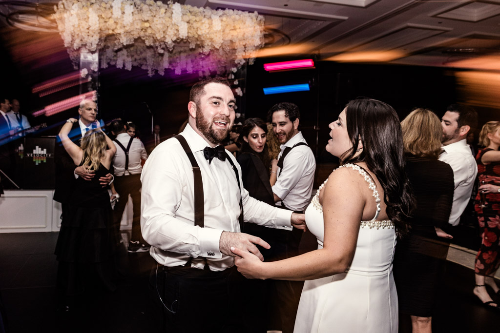 Groom and bride dance at their wedding reception at The Four Seasons Chicago, surrounded by other guests on the dance floor