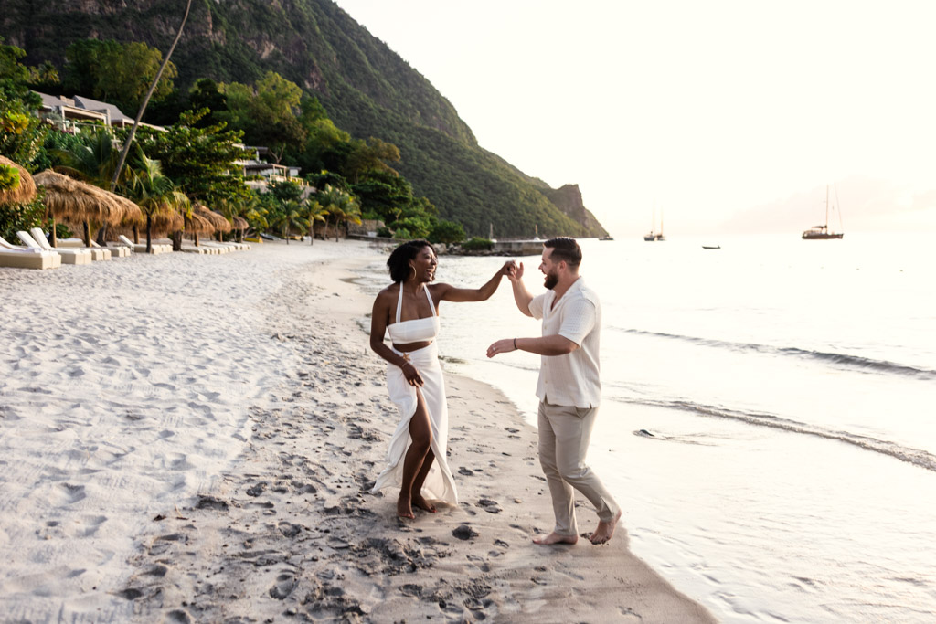 Newlywed couple dances barefoot on the shore at Viceroy Sugar Beach at sunset