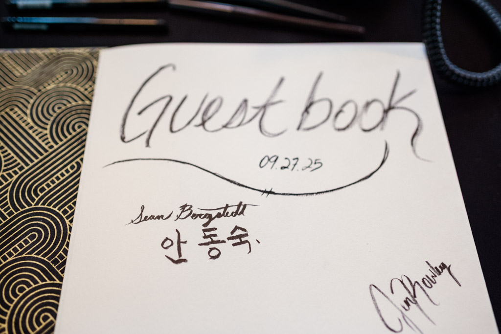 An open guest book from the Wildman BT wedding, signed with handwritten names, a date (09.27.25), and a heartfelt message in Korean.