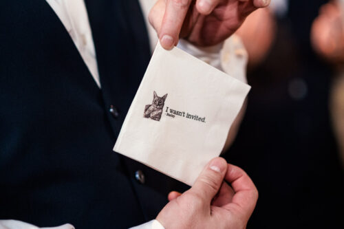 Custom cocktail napkin with a cat illustration and the text, "I wasn’t invited," for 1920s-themed wedding reception at Wildman BT in Chicago