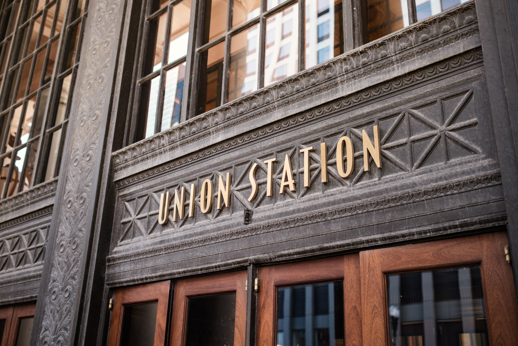 Close-up of the Union Station sign above wooden doors on an ornate building facade, capturing the grand entrance used for the Wildman BT wedding.