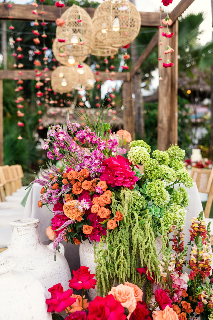 Colorful floral centerpiece with roses and greenery on a decorated outdoor table at a Frente al Punto wedding